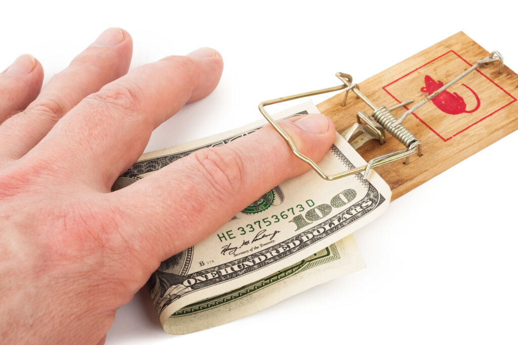 finger getting caught in mouse trap holding money