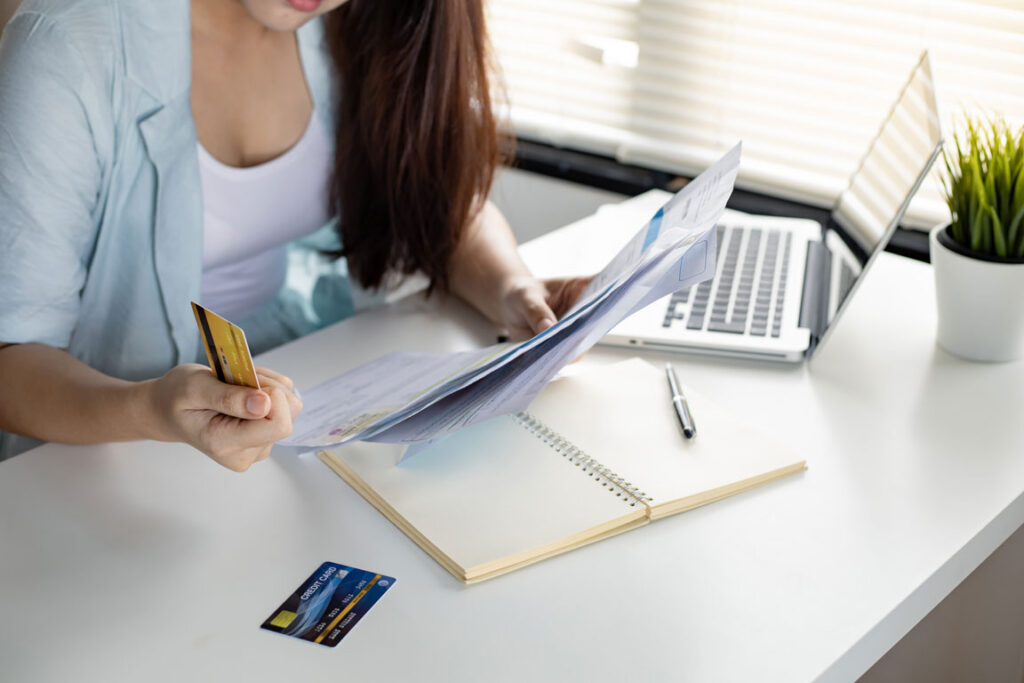woman in front of laptop struggling with credit card debt