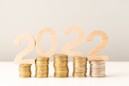wooden 2022 over stacks of coins