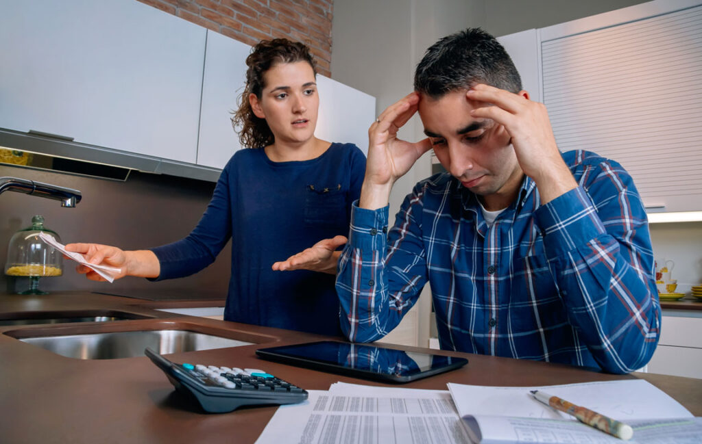 couple struggling in debt at kitchen table