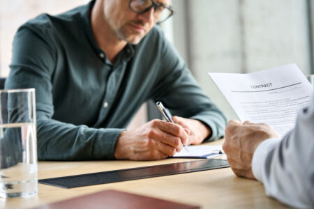 businessman signing contract with lawyer
