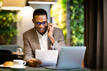 black businessman making a phone call in front of his laptop