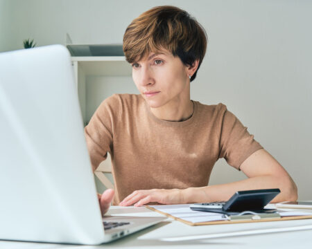 woman in front of laptop calculating financial data