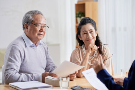 elderly Asian couple meeting with estate planning attorney