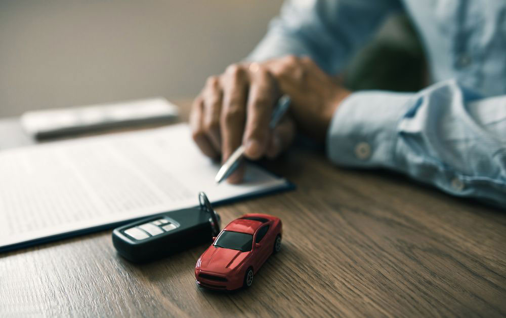 man signing an auto loan