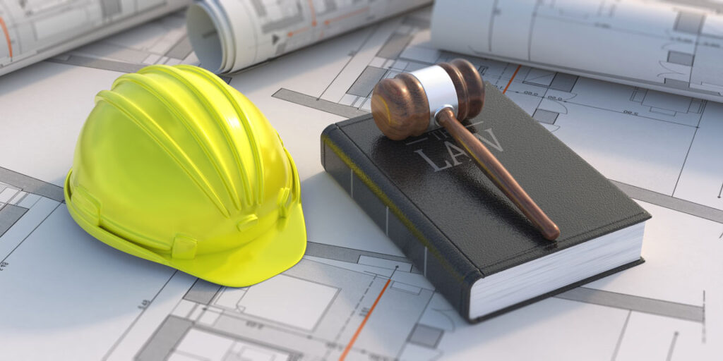 construction hardhat and law book with gavel over blueprints