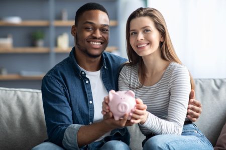 married couple holding a piggy bank