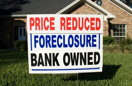 a foreclosure sign in front of a home