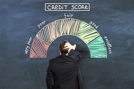 Man scratching his head looking up at a credit card score rating chart