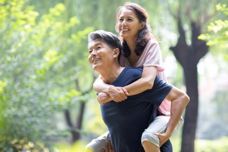 elderly people walking through woods smiling